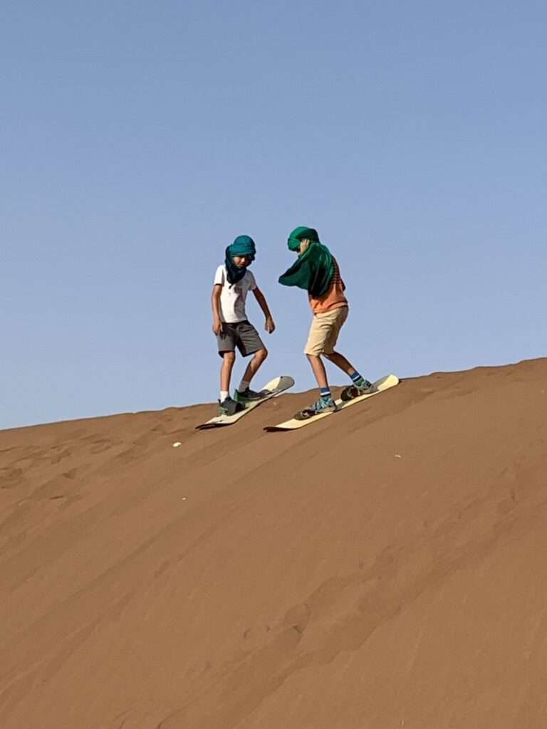Niños surf dunas Erg Chigaga desierto Marruecos